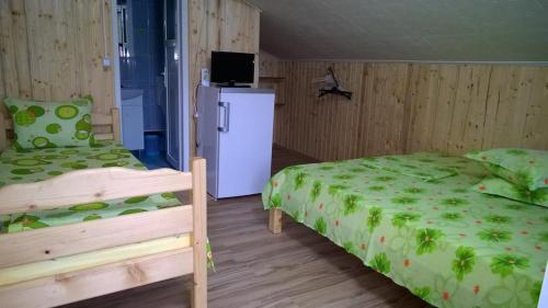 a bedroom with a bed and a white refrigerator at Vila MariCris in Tuzla
