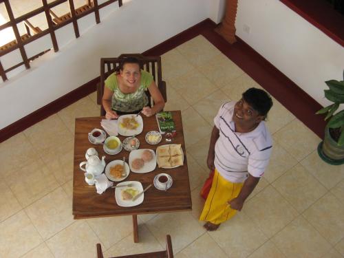 two people sitting at a table with plates of food at Castle Bay Resort in Weligama