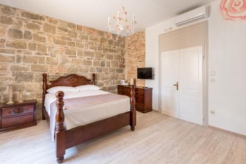 a bedroom with a bed and a brick wall at Pietra Rossa in Split