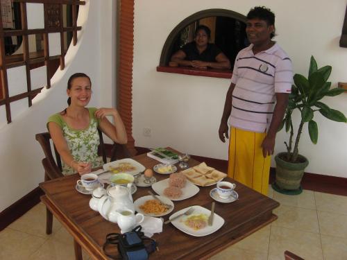 a man and a woman sitting at a table with food at Castle Bay Resort in Weligama