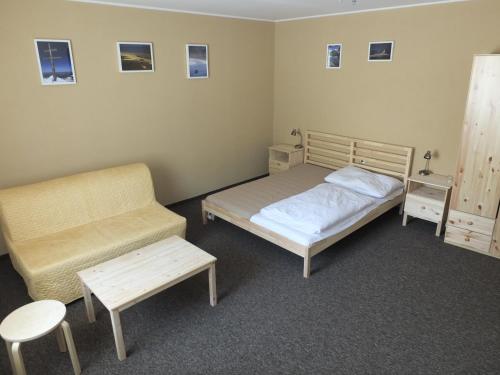 a bedroom with two beds and a chair and a table at Penzion Zornicka in Donovaly