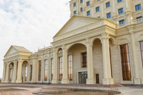 a large white building with columns at Sultan Palace Hotel in Atyrau
