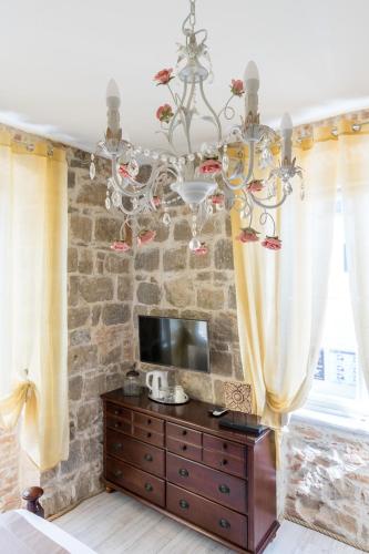 a living room with a chandelier and a wooden dresser at Pietra Rossa in Split