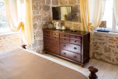 um quarto com uma cómoda e uma televisão por cima em Pietra Rossa em Split