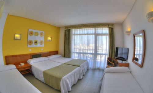 a hotel room with two beds and a television at Hotel & Spa Entremares in La Manga del Mar Menor