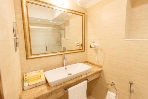 a bathroom with a sink and a mirror at Sultan Palace Hotel in Atyrau