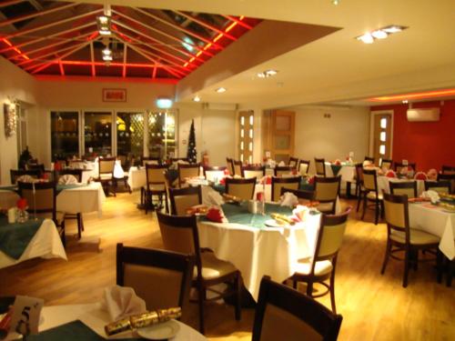 a dining room with white tables and chairs at The Anchor Ely in Ely