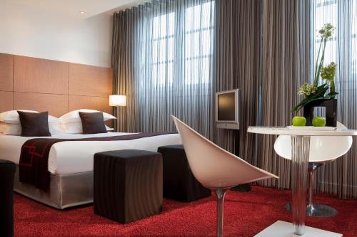a hotel room with a bed and a table at Villathena in Paris