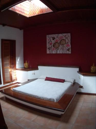a bedroom with a large bed in a red wall at Vivienda vacacional Finca Ribera De Cortes in Nazaret