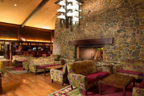 a lobby with chairs and a stone wall at Disney Sequoia Lodge in Coupvray