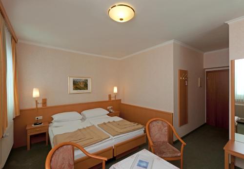 a hotel room with a bed and a table at Hotel Hallerhof in Bad Hall