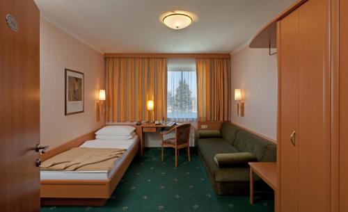 バート・ハルにあるHotel Hallerhofのベッドとソファ付きのホテルルーム