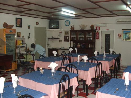 a dining room with tables with pink and blue tablecloths at Hotel Piccolo Paradiso in Peschici