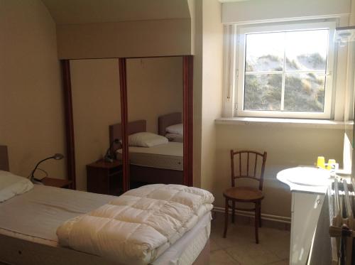オーストダインケルケにあるVilla Wapiのベッドルーム1室(ベッド1台、窓、鏡付)