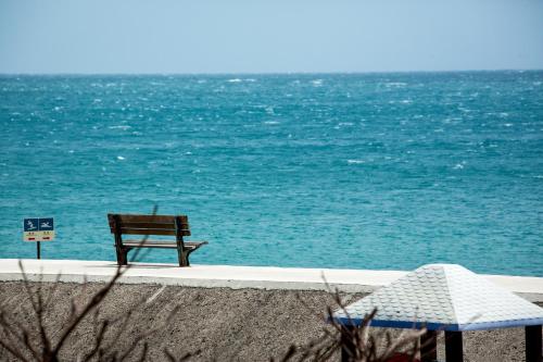 a bench sitting on the beach next to the ocean at Beachcastle & Sea View Villa in Magong