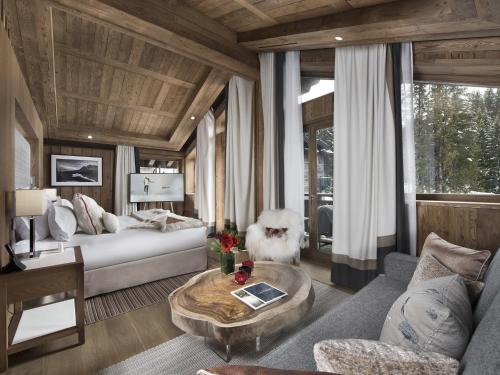 uma sala de estar com um sofá e uma mesa em Hôtel Barrière Les Neiges Courchevel em Courchevel