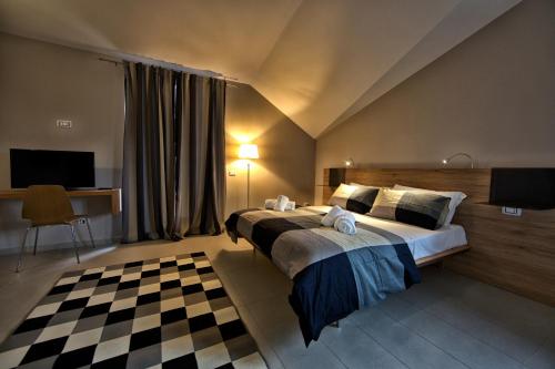 a bedroom with a large bed with a checkered floor at lepini suites affittacamere in Patrica