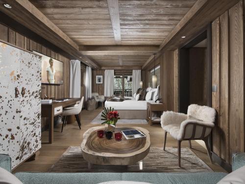 a bedroom with a bed and a living room with a table at Hôtel Barrière Les Neiges Courchevel in Courchevel