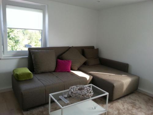 a living room with a brown couch and a window at Ferienwohnung Christa in Bad Staffelstein