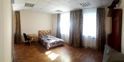 トムスクにあるCity Houseのベッドルーム1室(ベッド1台、テーブル、窓付)