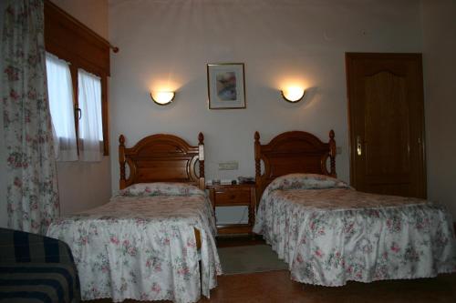 a hotel room with two beds and a window at Hotel Can Mestre in El Pont de Suert