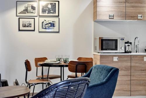 - un salon avec une table, des chaises et un four micro-ondes dans l'établissement My Maison In Paris - Sentier, à Paris
