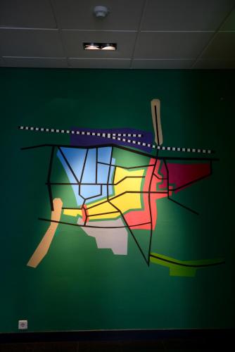 a colorful painting on a green wall in a room at Hostel Roots in Tilburg