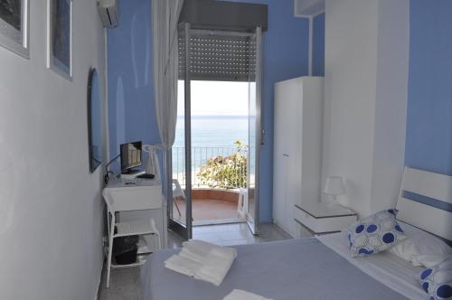a bedroom with a bed and a view of the ocean at Hotel Ristorante La Scogliera - NUOVA GESTIONE in Piraino