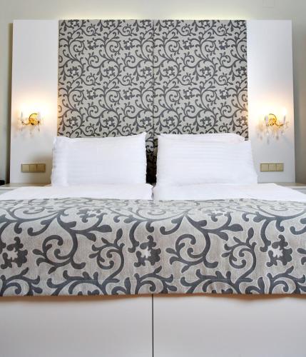 a bedroom with a bed with a large headboard at Hotel Wandl in Vienna