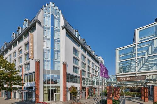 um grande edifício branco numa rua da cidade em Mercure Hotel Berlin Tempelhof em Berlim