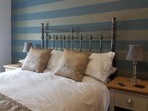 a bed with white sheets and pillows on it at Croft Guesthouse in Cockermouth