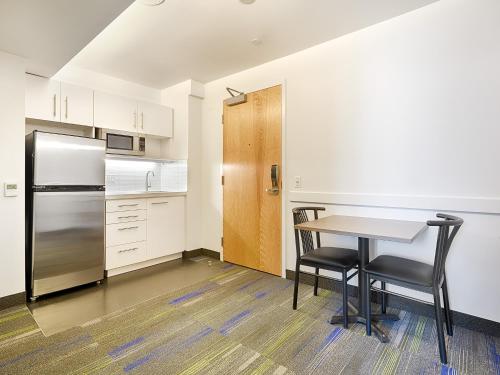 eine Küche mit einem Tisch und einem Kühlschrank in der Unterkunft Residence & Conference Centre - Toronto Downtown in Toronto