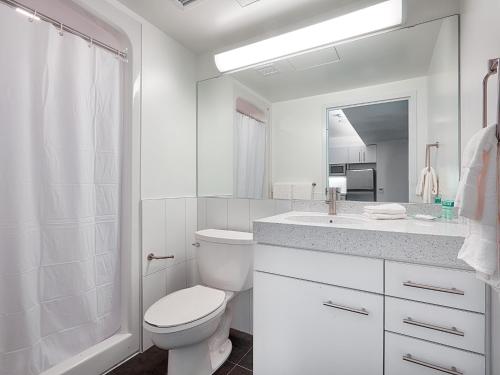 Baño blanco con aseo y lavamanos en Residence & Conference Centre - Toronto Downtown en Toronto