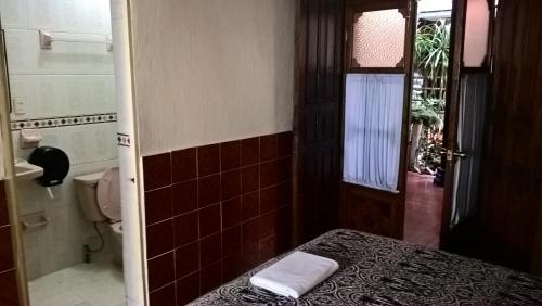 Habitación pequeña con cama y baño. en Hotel La Casona en San Cristóbal de Las Casas