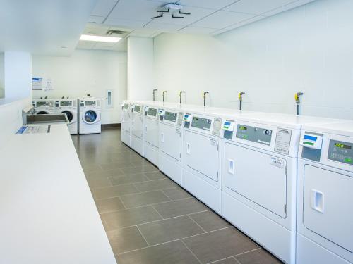 a laundry room with a row of washers and dryers at Residence & Conference Centre - Toronto Downtown in Toronto