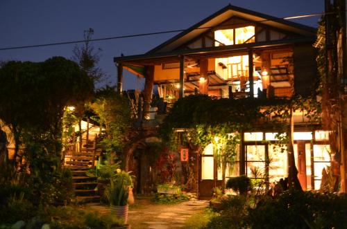 a large house with lit up windows at night at Good Harvest B&B in Chishang