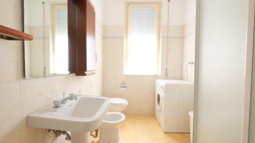een witte badkamer met een wastafel en een toilet bij Orchidea 2 Pineto Vacanza in Pineto