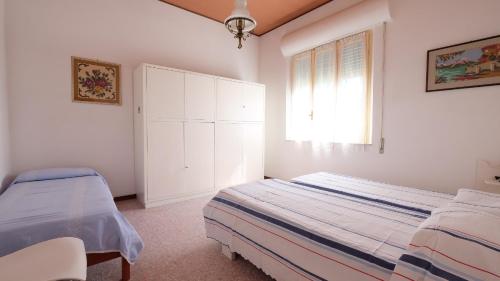 - une chambre blanche avec un lit et une fenêtre dans l'établissement Orchidea 2 Pineto Vacanza, à Pineto