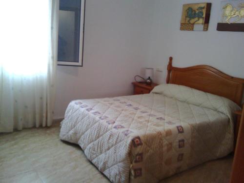 カルボネラスにあるApartamento Triniの窓付きの部屋にベッド付きのベッドルーム1室があります。
