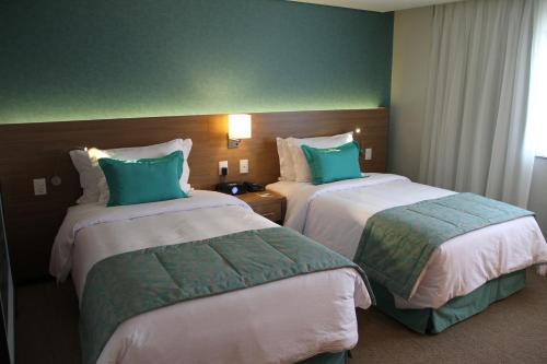 a hotel room with two beds with green and white at Radisson Hotel Belém in Belém