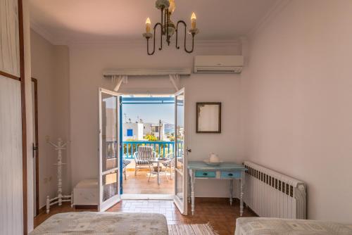 een slaapkamer met een deur naar een balkon bij Traditional House Milos in Pollonia
