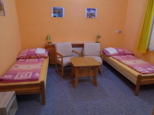 a room with three beds and a table and chairs at Pension Dobroucky in Prague