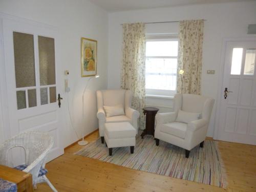 a living room with two chairs and a window at Stieglerhof KG in Illmitz