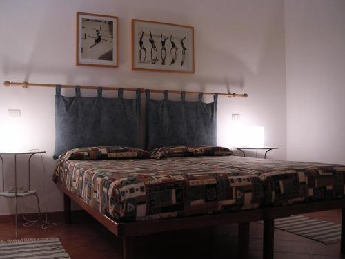 a bedroom with a bed with two lamps and two pictures on the wall at Residence Villa La Pineta in Cavo