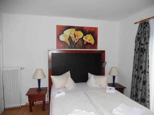 a bedroom with a bed with a painting on the wall at Hotel Edelweiß in Oberau