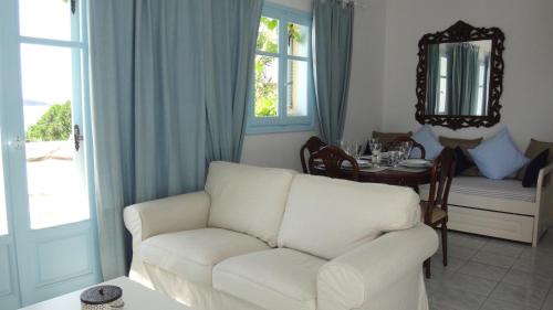 a living room with a white couch and a table at Blue & Sea Studios Apartments in Drios