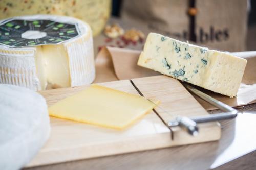 a block of cheese on a cutting board with a block of cheese at Gästeresidenz Pelikan Viertel Hannover in Hannover
