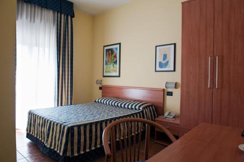 a hotel room with a bed and a table at Hotel Blue Ribbon in Vercelli