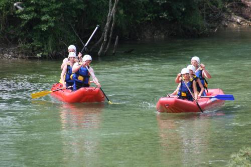 a group of people in kayaks on a river at Apartments and rooms Cerkovnik in Bohinj