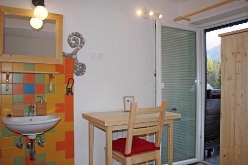 a bathroom with a sink and a table and a mirror at Apartments and rooms Cerkovnik in Bohinj